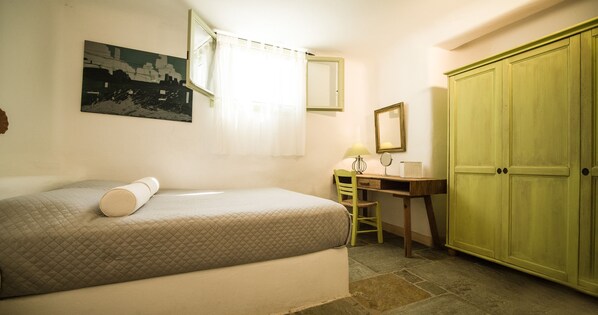 A bedroom with a bed, a desk, a chair, a wardrobe, a mirror, and a painting on the wall. - "Secluded Elegance: Three-Level Villa with Ocean Views, Pool, and Outdoor Oasis" (Lagkeri)