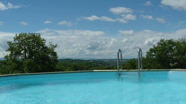 A clear blue pool with metal ladders, surrounded by trees and a mountainous landscape. - Peaceful Gite + PRIVATE Pool Exclusively for you +Magnificent Panoramic Views  (Lalanne)