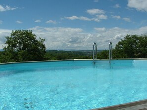 A clear blue pool with metal ladders, surrounded by trees and a mountainous landscape. - Peaceful Gite + PRIVATE Pool Exclusively for you +Magnificent Panoramic Views (Lalanne)