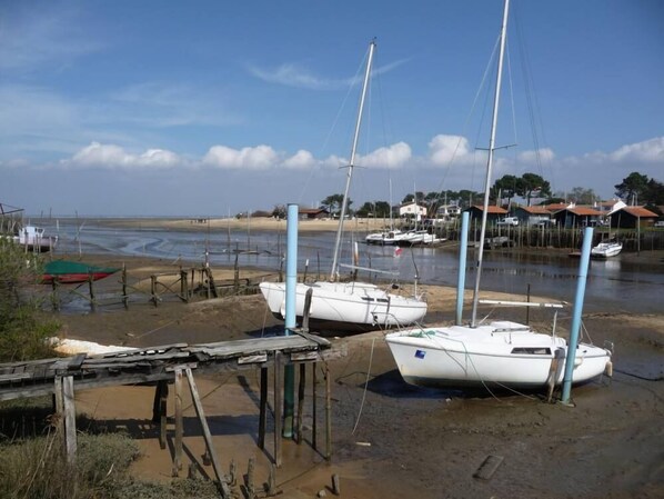 A marina with several boats docked, a sandy beach, and a few buildings in the background. - Classified 3 *** 200m from Arcachon Bay + 2 mountain bikes available! (La Teste-De-Buch)