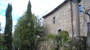 A stone building with a small window and a door, surrounded by a stone wall and greenery. - HillsideVilla overlooking the Tuscan landscape between Florence Arezzo and Siena (Loro Ciuffenna)