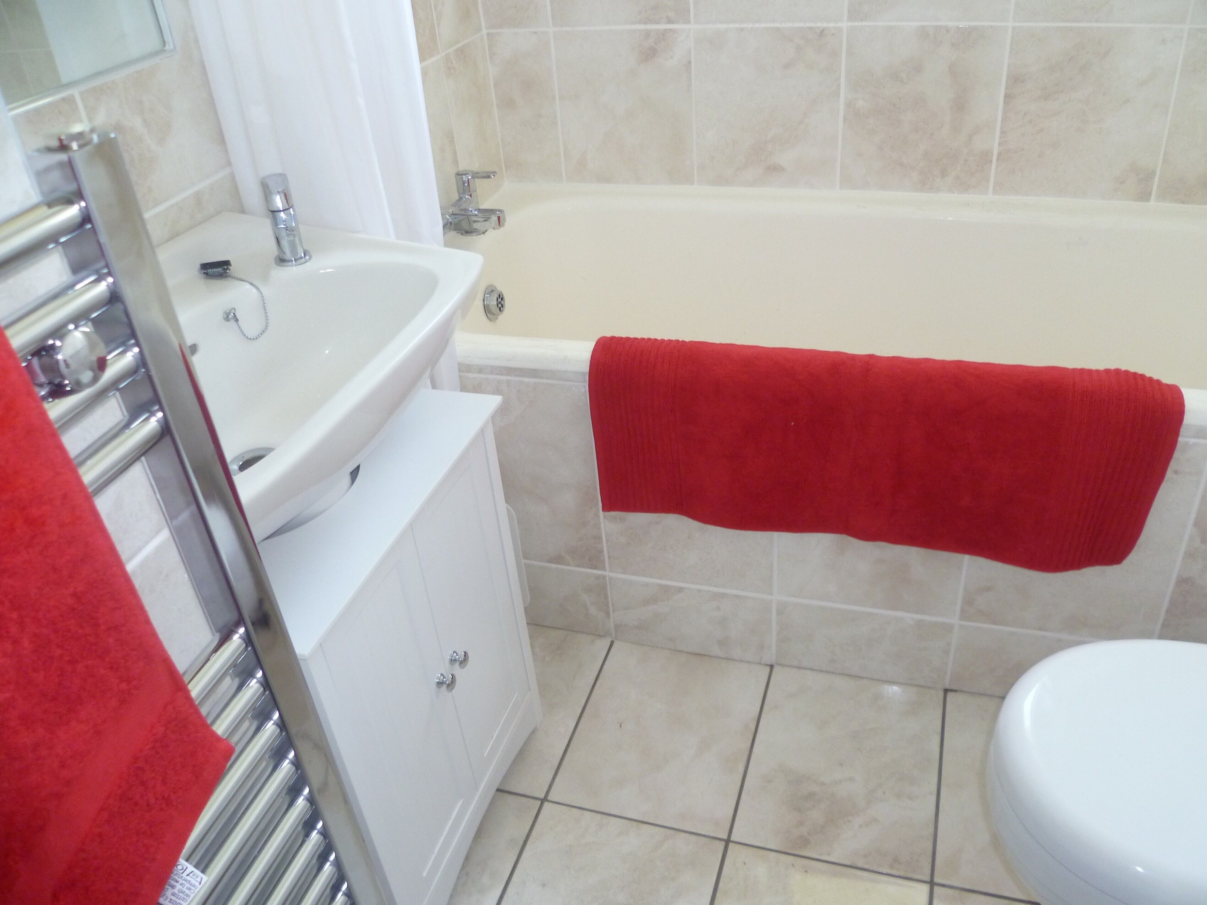 Un baño con un lavamanos blanco, una bañera y un inodoro.