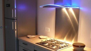 Eine moderne Küche mit einem Edelstahlkühlschrank, einem Gasherd und einem eingebauten Backofen.