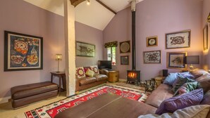 A cozy living room with a fireplace, leather sofas, and a variety of framed artwork on the walls. - Apple Tree Barn, Langham, Norfolk (Langham)