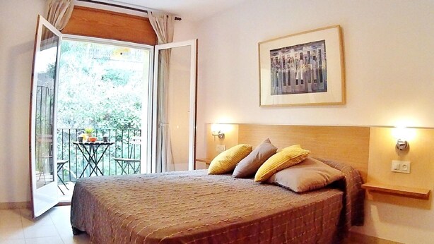 A bedroom with a bed, a balcony, and a framed picture on the wall. - Villa in Platja de Pals near Begur (Costa Brava) (Pals)