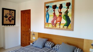 A bedroom with a bed, pillows, a wooden door, and a painting on the wall. - Villa in Platja de Pals near Begur (Costa Brava) (Pals)