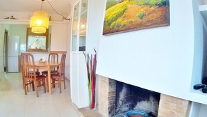 A dining area with a wooden table and chairs, a white fireplace, and a painting above the mantel. - Villa in Platja de Pals near Begur (Costa Brava) (Pals)