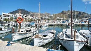 A marina with boats docked, a lifebuoy, and buildings in the background. - VILLA SIQUIER - LUXURY RETREAT WITH MOUNTAIN VIEWS (Pollensa)