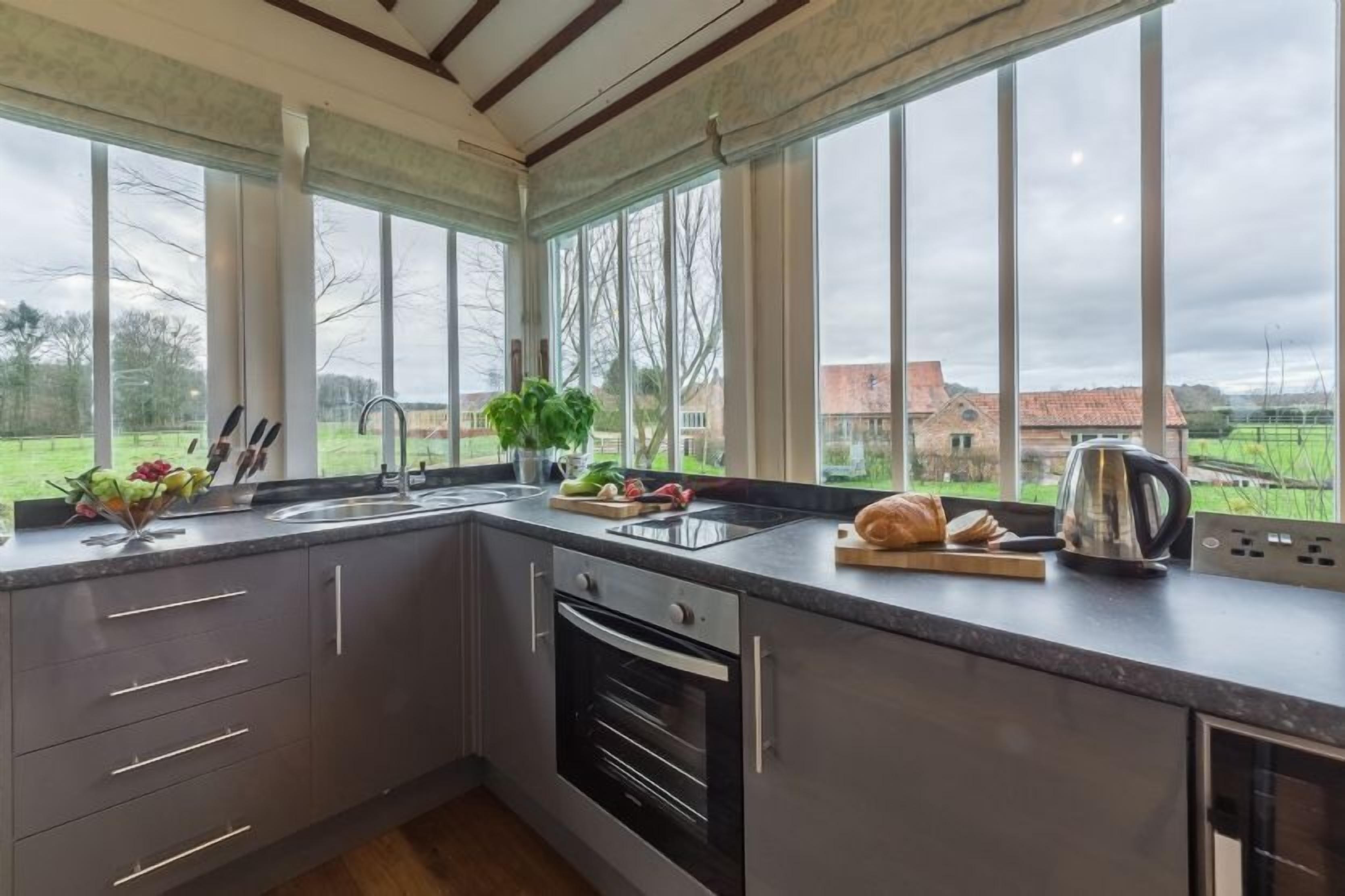 A modern kitchen with a large window, a sink, and a built-in oven.