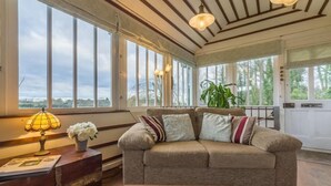 Ein gemütliches Wohnzimmer mit einer Couch, einer Lampe und einer Pflanze.