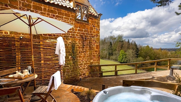 A stone building with a hot tub and outdoor seating area. - A spacious and luxurious retreat for couples near Great Tew (Chipping Norton)