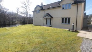 Ein zweistöckiges Haus mit geneigtem Dach, einer Haustür und einer kleinen Veranda.