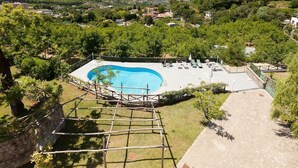 A pool area with a clear blue pool, surrounded by a wooden deck and lounge chairs. - Villa Yuri with private pool (Massa Lubrense)