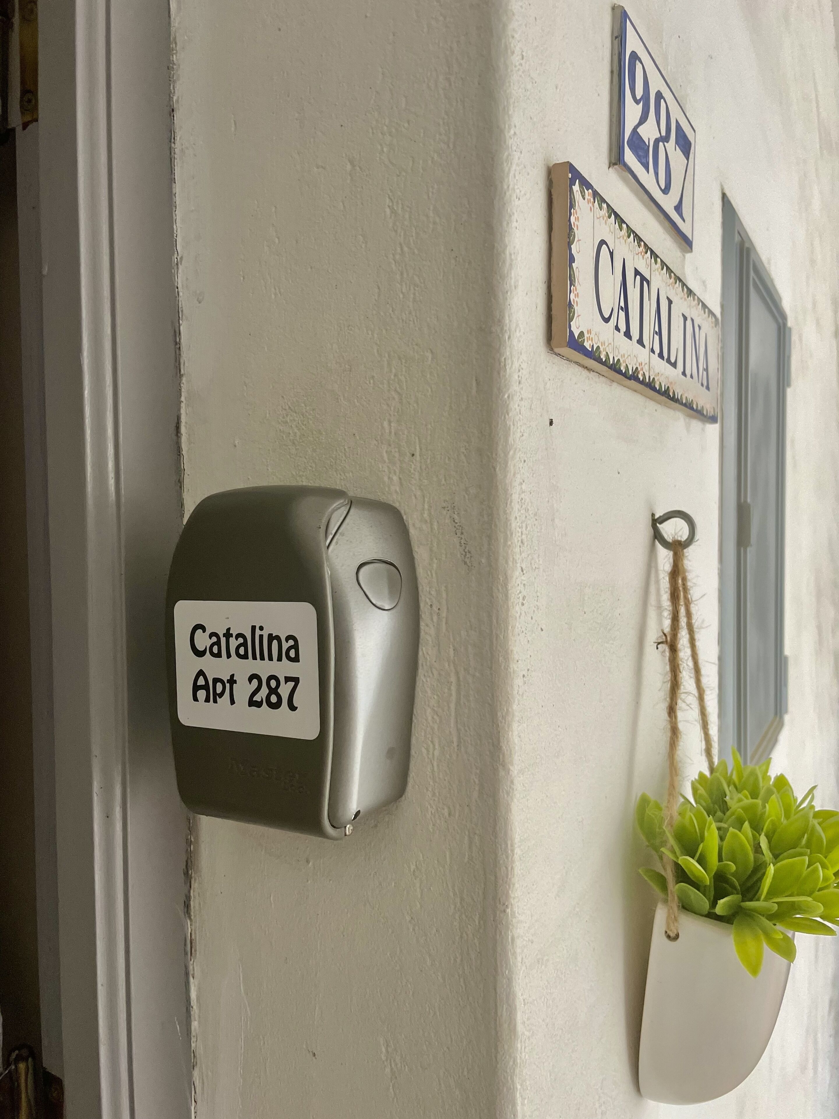 En postkasse med et skilt, der viser "Catalina Apt 287", monteret på en væg.