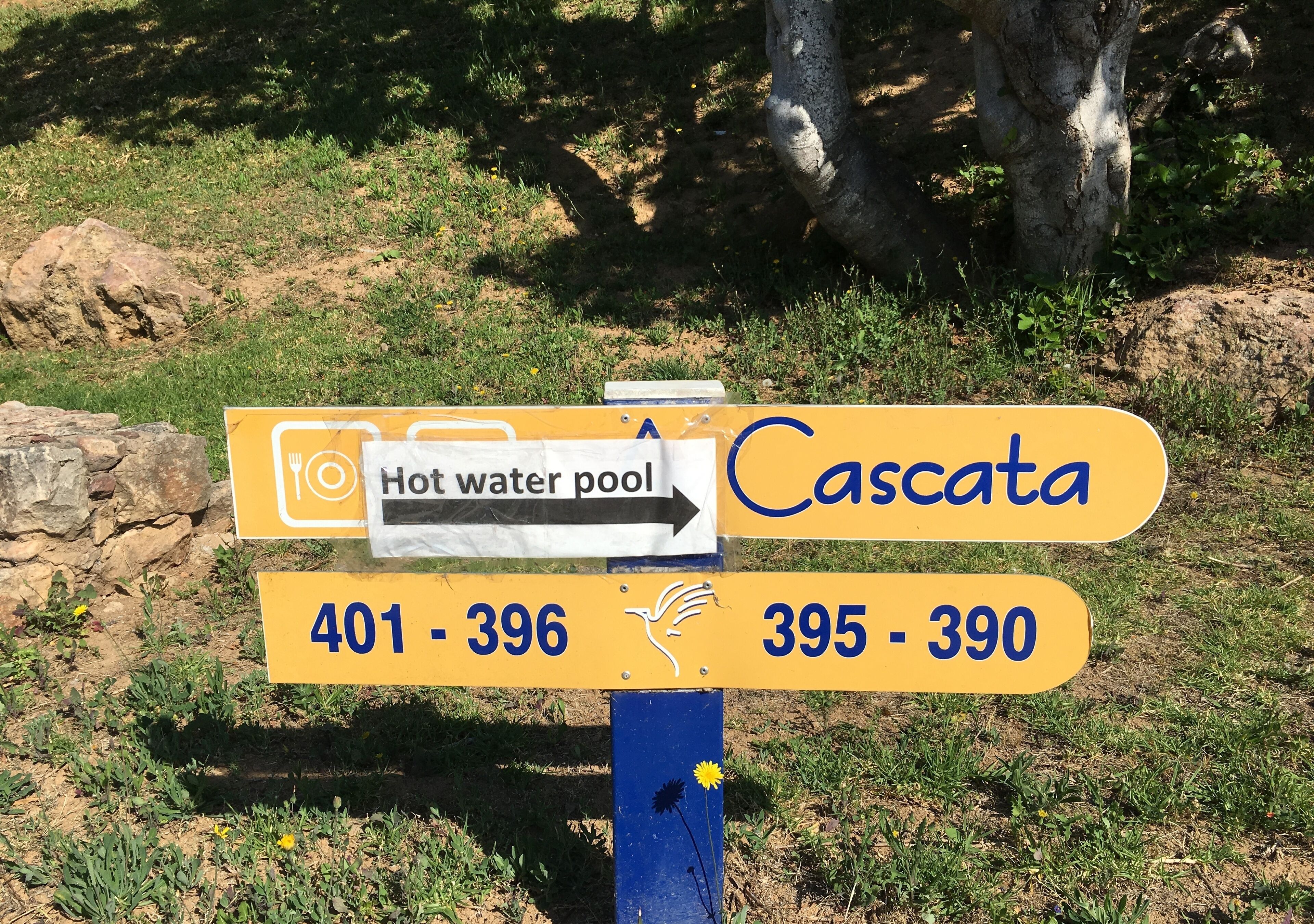 A directional sign with 'Hot water pool' and 'Cascata' directions, and route numbers 401-396 and 395-390.