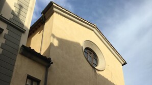A building with a beige facade, a round window, and two posters on the wall. - Under the roof of Sofia (Florence)