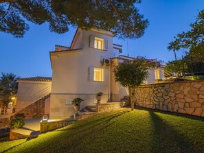 A two-story building with a stone wall and a staircase leading to the entrance. - Villa Alcanada Sunrise. Your villa with private pool and sea views in Alcanada. (Alcúdia)