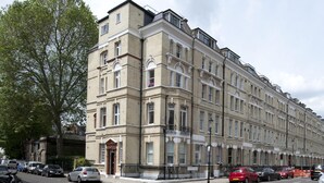 A multi-story building with a classic architectural style, featuring a symmetrical facade, large windows, and a prominent corner entrance. - Splendid, light and spacious apartment between Fulham and Kings Rd Chelsea. (London)