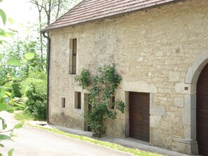 Ein Gebäude aus Stein mit Ziegeldach, kleinem Fenster und einer Tür.
