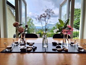 Een tafel met bloemen en kaarsen, met een mooi uitzicht op de omgeving.
