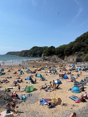 A crowded beach with numerous tents and people enjoying the sunny day. - Cosy Coastal Retreat | 3 min walk to beach | Perfect for families | Free parking (Caswell Bay)