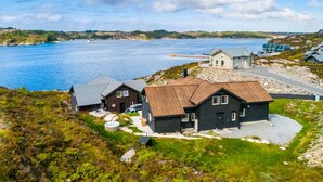 A coastal property with multiple houses, a dock, and a clear view of the sea.