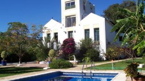 Un edificio moderno de dos pisos con una piscina al frente.