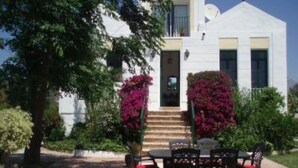 Una casa moderna con un patio que tiene una mesa y sillas.