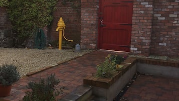 Stroll through the charming outdoor space, surrounded by lush greenery and brick walls.