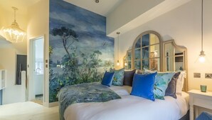 A bedroom with a large bed, a mural on the wall, a dresser, and a chair. - No. 33 Cottage 2, Thornham, Norfolk (Thornham)