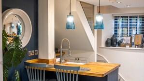 A modern kitchen with a wooden island, two grey chairs, and pendant lights. - No. 33 Cottage 2, Thornham, Norfolk (Thornham)