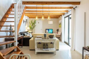 A living room with a staircase, a sofa, a coffee table, and a television. - Special offer: House w / pool set in a romantic and idyllic location. (Prazeres - Calheta)