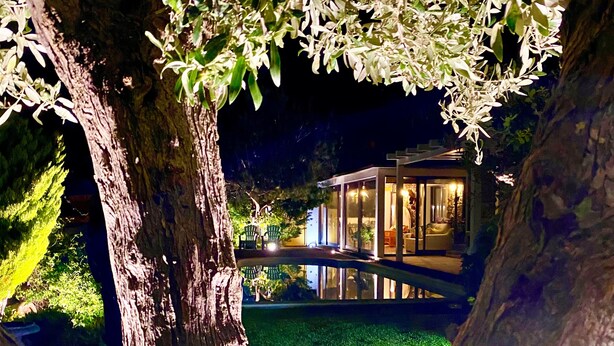 Un bâtiment moderne aux murs de verre, entouré d’arbres et d’une pelouse bien entretenue.