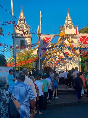 A church with a clock tower and a crowd of people in front.