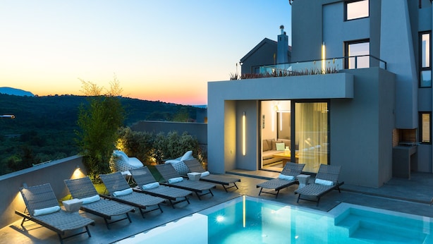 A modern house with a swimming pool, lounge chairs, and a view of the countryside. - Villa Blanche - Top quality villa surrounded by nature, close to the beach (Chania)