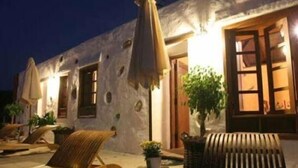 A building with a rustic exterior, wooden furniture, and potted plants. - Rural house (full rental) Finca Los Ciruelos for 2 people (Icod de los Vinos)
