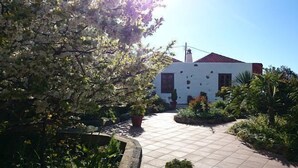 A building with a tiled patio, surrounded by lush greenery and a clear sky. - Rural house (full rental) Finca Los Ciruelos for 2 people (Icod de los Vinos)