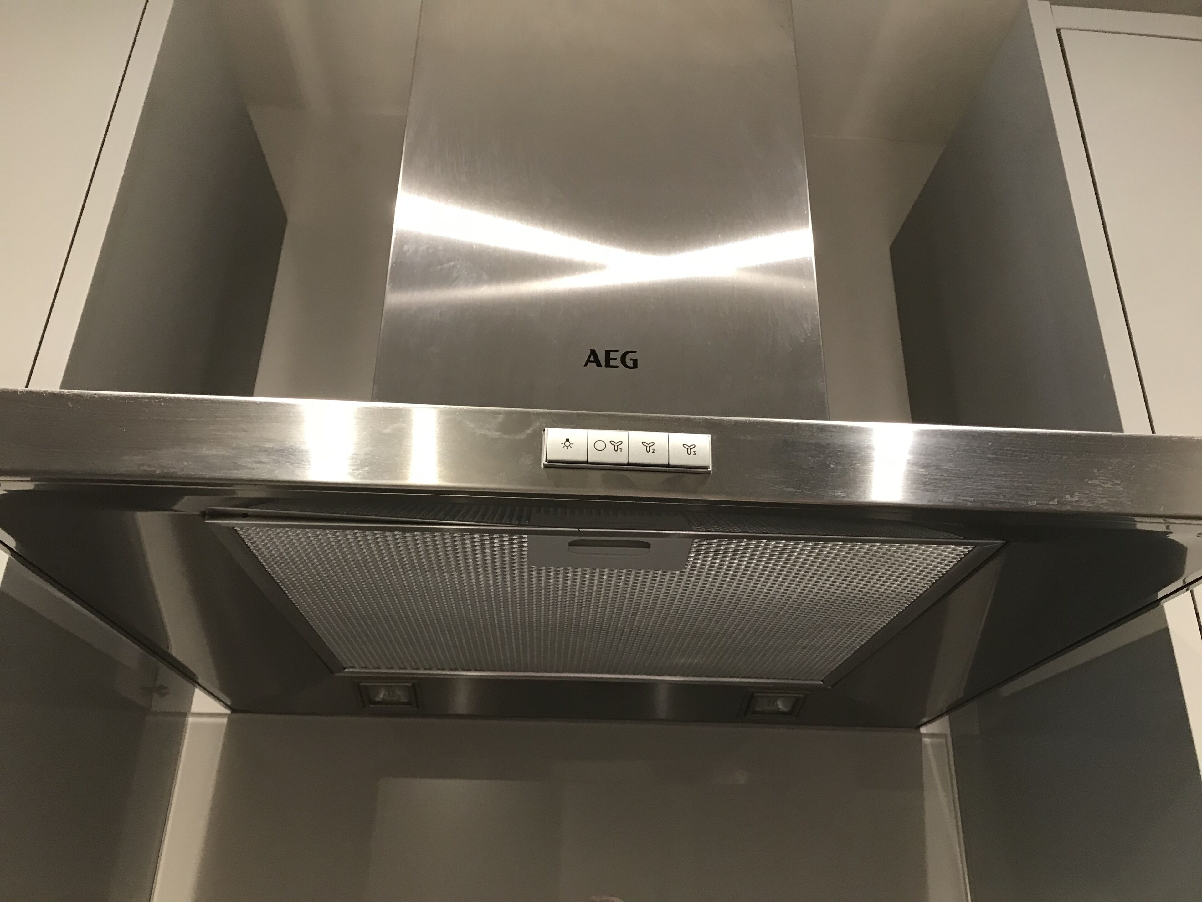 A stainless steel range hood with the brand name 'AEG' and control buttons.