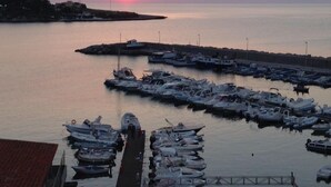 A marina with multiple boats docked at the pier during sunset.