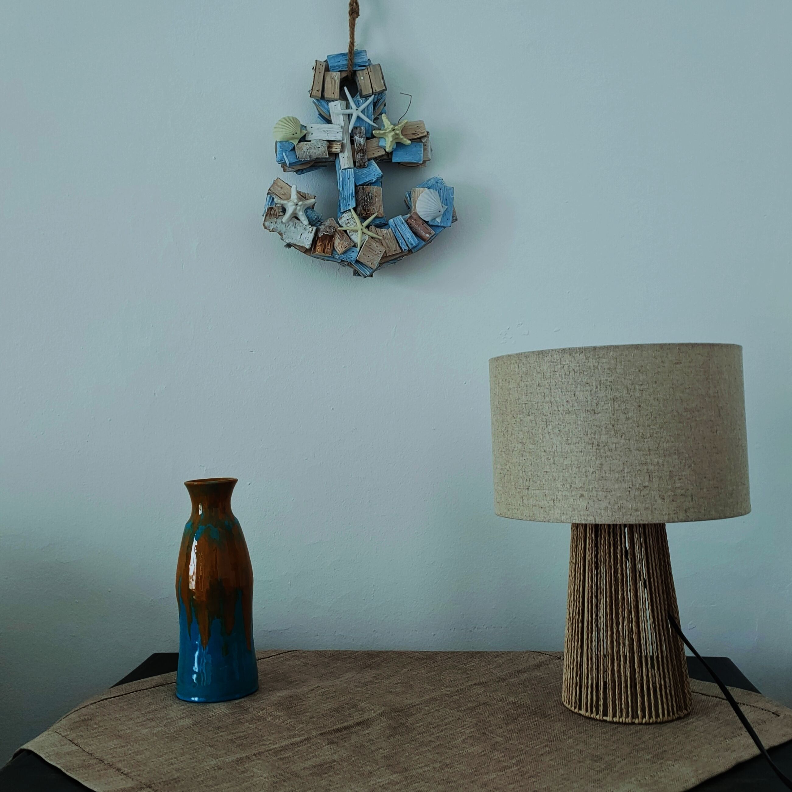 Une table avec un vase et une lampe.