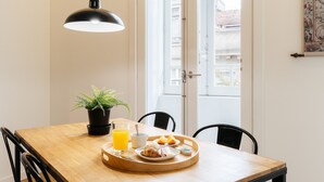 A dining table with breakfast items, a potted plant, and a pendant light. - Galerias On Trend Nightlife by Feel Porto (Oporto)