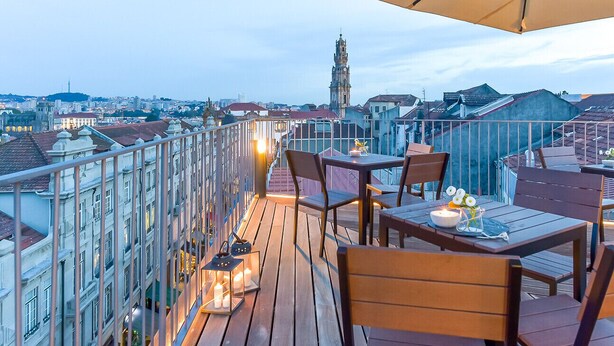 A rooftop terrace with wooden flooring, tables, chairs, and a large umbrella. - Galerias On Trend Nightlife by Feel Porto (Oporto)