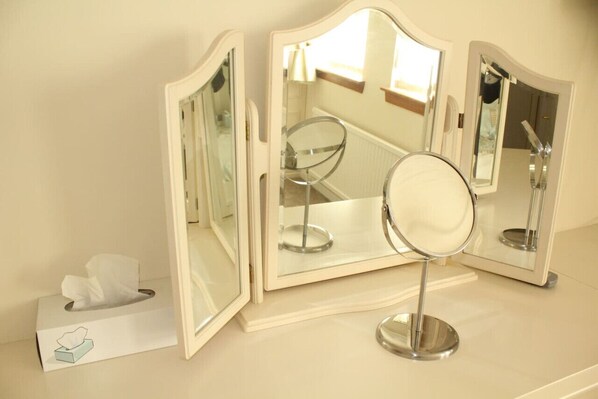A vanity setup with a mirror and two side mirrors, a tissue box, and a window with natural light. - Abbot`s House in Doonfoot (Doonfoot)