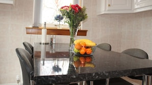 A dining table with a vase of flowers and a bowl of fruit in the center. - Abbot`s House in Doonfoot (Doonfoot)
