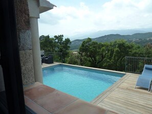 Une piscine avec vue sur les montagnes et les arbres.
