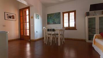 Un coin repas comprenant une table et des chaises, un buffet et un tableau accroché au mur.