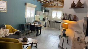 A modern kitchen with a dining area, a sofa, and a lamp.