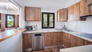 A modern kitchen with wooden cabinets, a dishwasher, a microwave, and a sink.