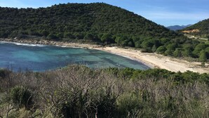 A coastal landscape with a beach, clear turquoise waters, and a forested hill. - Villa sea view heated pool 8 persons with electric charging point (Sainte Lucie de Porto Vecchio)