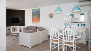 Un salon moderne avec un canapé, une table à manger et des chaises.